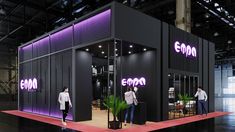 an exhibition stand with people standing in front of it and purple lighting on the walls