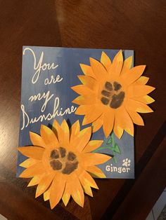 two sunflowers on a table with a card that says you are my sunshine