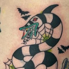 a black and white snake with green eyes on it's back side tattoo design