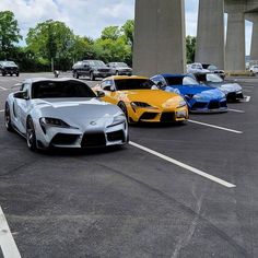 four different colored sports cars parked in a parking lot