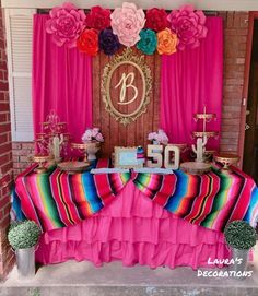 the table is decorated with colorful flowers and decorations for an adult birthday party or baby shower