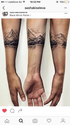 two hands holding each other with mountains and trees tattooed on their arms, both showing the same