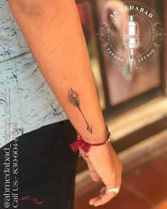 a person with a tattoo on their arm holding the hand of another person's wrist