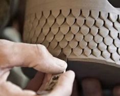 a person is working on a piece of pottery with their fingers and thumbnails