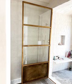 a bathroom with a glass shower door and tiled floor