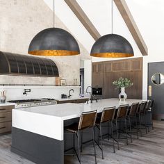 a large kitchen with an island and several lights hanging from the ceiling over it's counter tops