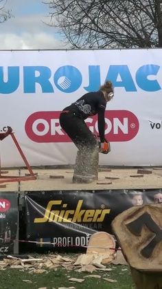 two snowboarders are doing tricks on the course in front of a large sign