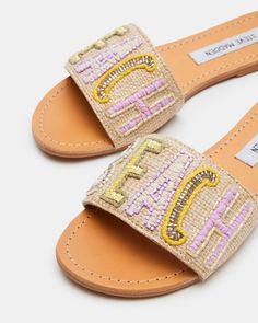 SUNNY + EASY + WHIMSICAL SEASIDE adds dynamic texture to a simple flat slide look with beaded embellishment on the wide front strap and decorative overstitching around the welt. Embellished flat slide sandal Slip-on style Beaded text design on woven strap Contrast overstitching around top of sole .25 inch heel height Textile upper material with beading Textile lining Leather sock Synthetic sole Imported Casual Embellished Flat Heel Sandals, Casual Flat Embellished Sandals, Casual Embellished Flat Sandals, Embellished Flats, Beaded Sandals, Leather Socks, All About Shoes, Text Design, Women's Sandals