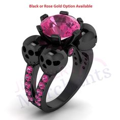 a black ring with skulls on it and a pink stone in the center, surrounded by diamonds