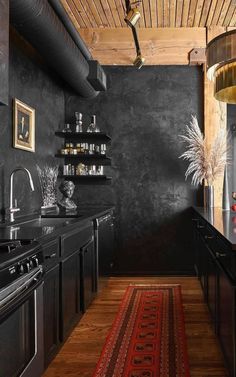 a kitchen with black walls and wooden floors, an area rug on the floor that matches the ceiling