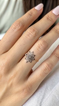 a woman's hand with a flower tattoo on her left thumb and the other half of her finger