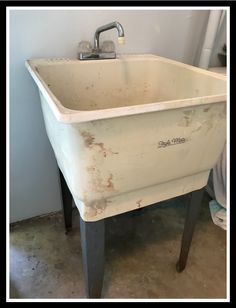 an old white sink sitting on top of a wooden table