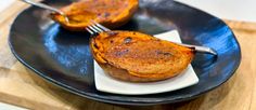 two baked sweet potatoes on a plate with a fork