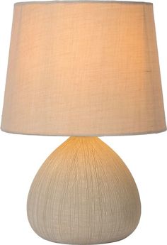 a white table lamp with a beige shade