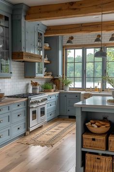 a large kitchen with blue cabinets and wooden floors is pictured in this image, there are wicker baskets on the island