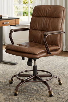 a brown leather office chair sitting on top of a carpeted floor next to a window