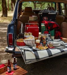 the back end of a car with picnic food and drinks in it, including beer