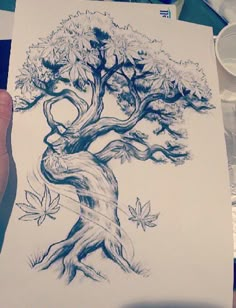 a person holding up a drawing of a tree