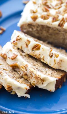 two slices of banana bread with white frosting and pecans on a blue plate