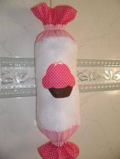 a pink and white bag with a cupcake on it hanging from the side of a door