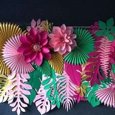 paper flowers and leaves arranged on a black background