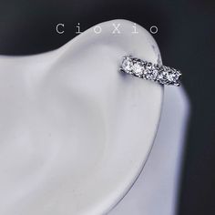 a diamond ring sitting on top of a white plate in front of a black background