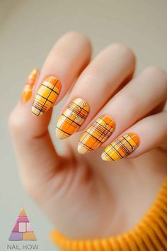 Bright and bold! These orange plaid nails are perfect for those who love to stand out. Ideal for Thanksgiving nails or any fall occasion, this design is vibrant and full of fun energy. Visit NailHow.com for more Thanksgiving nail ideas and save this pin for later! 🎃🍊 Orange Plaid Nails