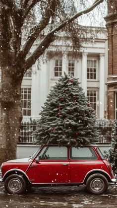 a small red car parked in front of a christmas tree