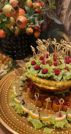 an elaborately decorated platter with fruit and appetizers on it's sides