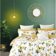 a bedroom with green walls and yellow flowers on the comforter, along with a round mirror