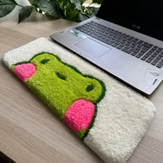 a laptop computer sitting on top of a desk next to a rug with an animal face