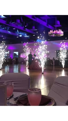 an empty dance floor is lit up with purple lights and sparkles in the background