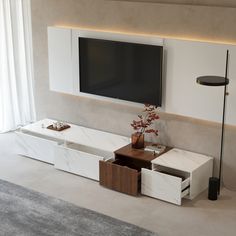 a living room with a television and white furniture