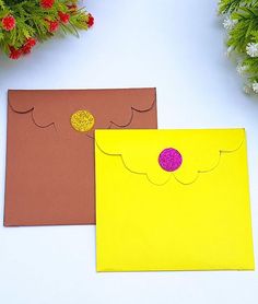 two pieces of paper are sitting next to each other on a white surface with red and yellow decorations