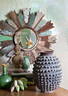 two vases sitting on top of a wooden table next to a mirror and books