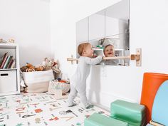 two young children playing in a playroom with toys