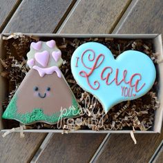 two decorated cookies are in a box on the table