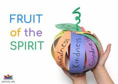 a hand holding an apple with the words fruit of the spirit taped to it's side