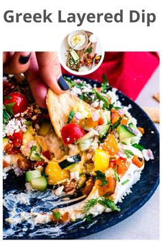 the greek layered dip is being served on a plate