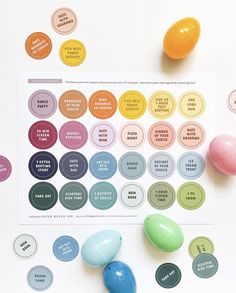 an assortment of colored eggs on top of a white table with stickers around them