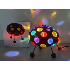 a colorful light up ball sitting on top of a table next to a card board