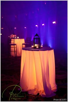 the table is covered with white cloth and lit candles