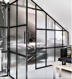 a living room with an open door to the bedroom and bathroom in black and white