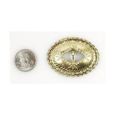 a small gold plated metal object next to a dime