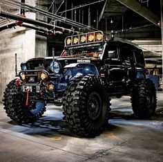 an off - road vehicle is parked in a parking garage with its lights turned on