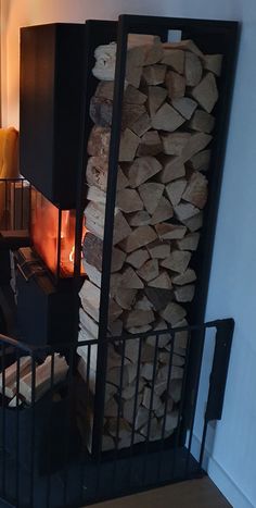 there is a fire place in the corner of this room with wood stacked on it