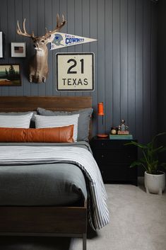 a bed room with a neatly made bed and a deer head mounted on the wall