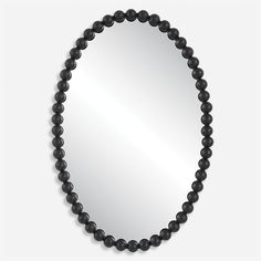 a black beaded mirror hanging on the wall