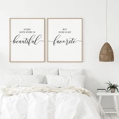 two posters on the wall above a bed in a room with white sheets and pillows