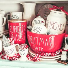 red christmas dishes and mugs are sitting on the shelf